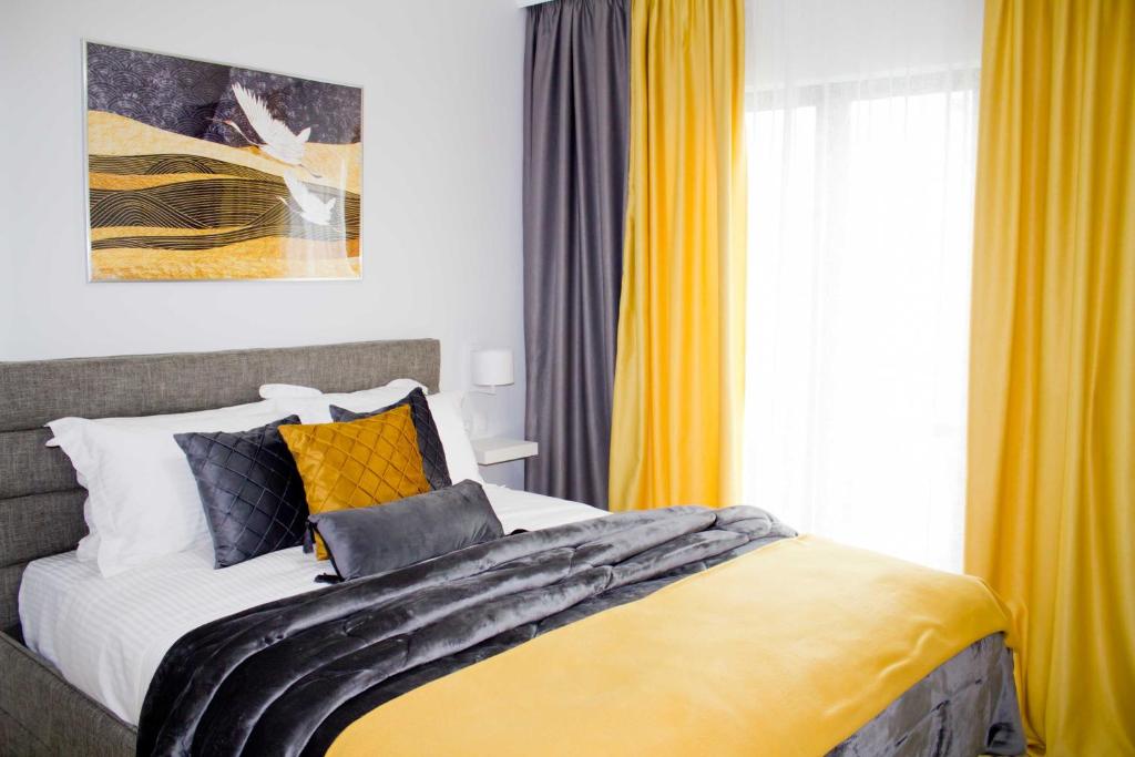 哈尔基斯Ermis Mini Suite # 3的一间卧室配有一张带黄色窗帘的大床