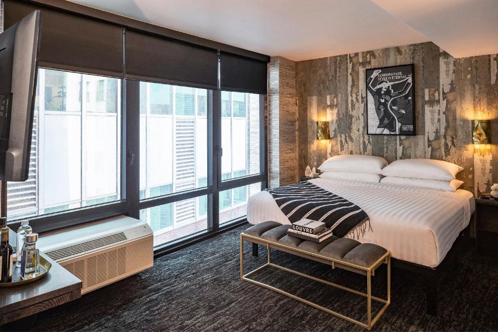 纽约The FIDI Hotel的一间卧室设有一张大床和大窗户