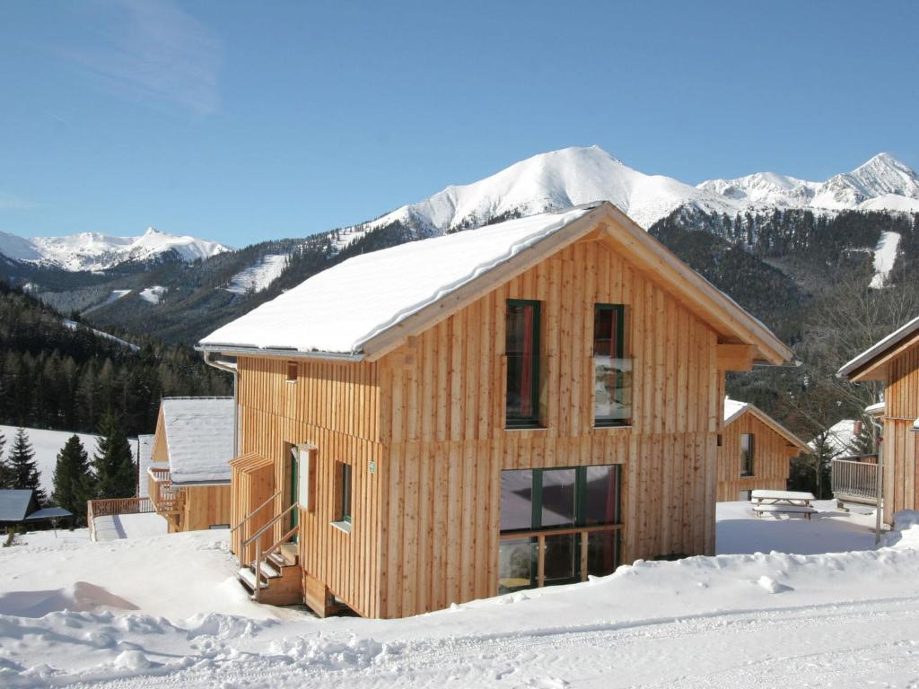 上陶恩Chalet in Hohtauern Styria with sauna的雪中木屋,背景是群山