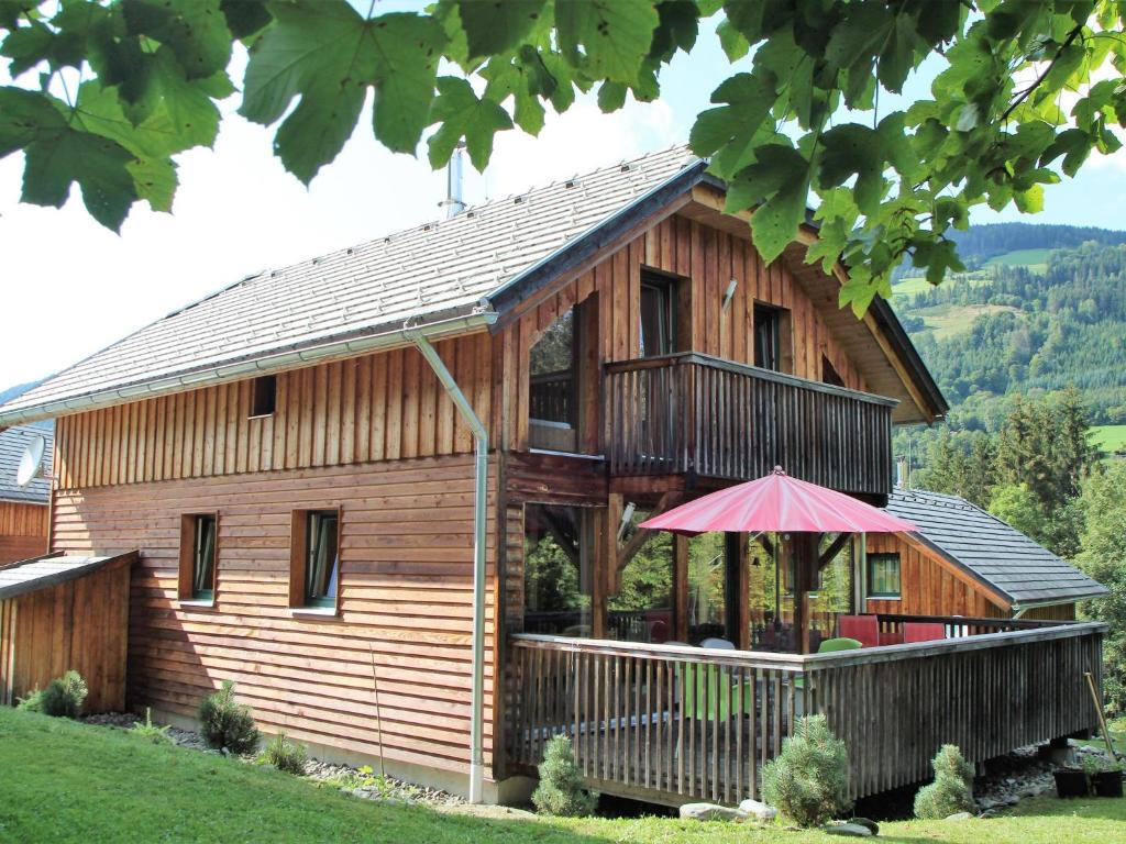 穆劳附近圣格奥尔根Chalet in St Georgen ob Murau near ski area的一座带门廊和遮阳伞的大型木屋