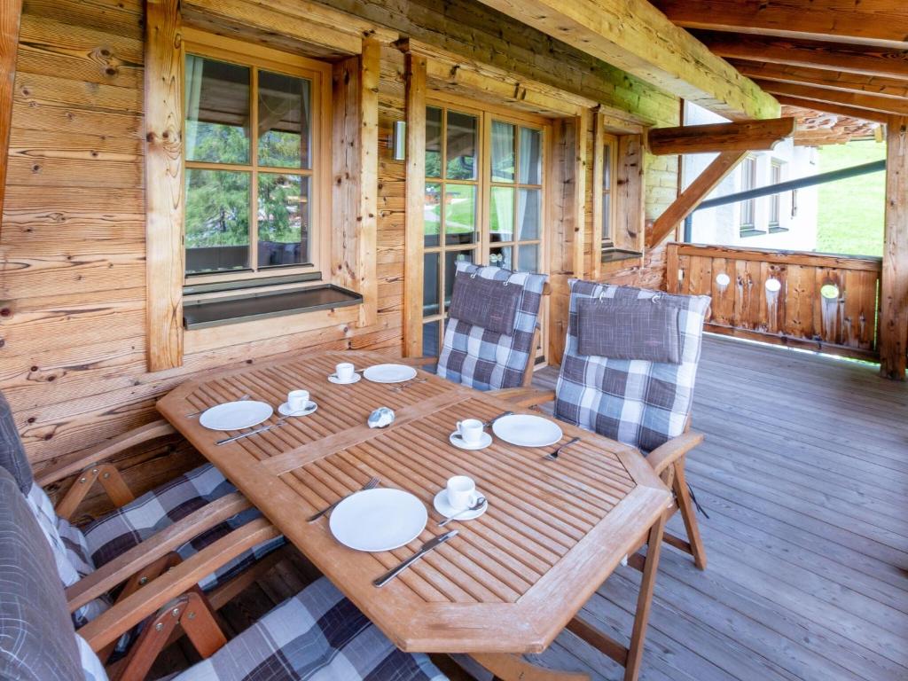 平茨高谷地霍勒尔斯巴赫Apartment near the ski area in Mittersill的小屋甲板上的木桌和椅子