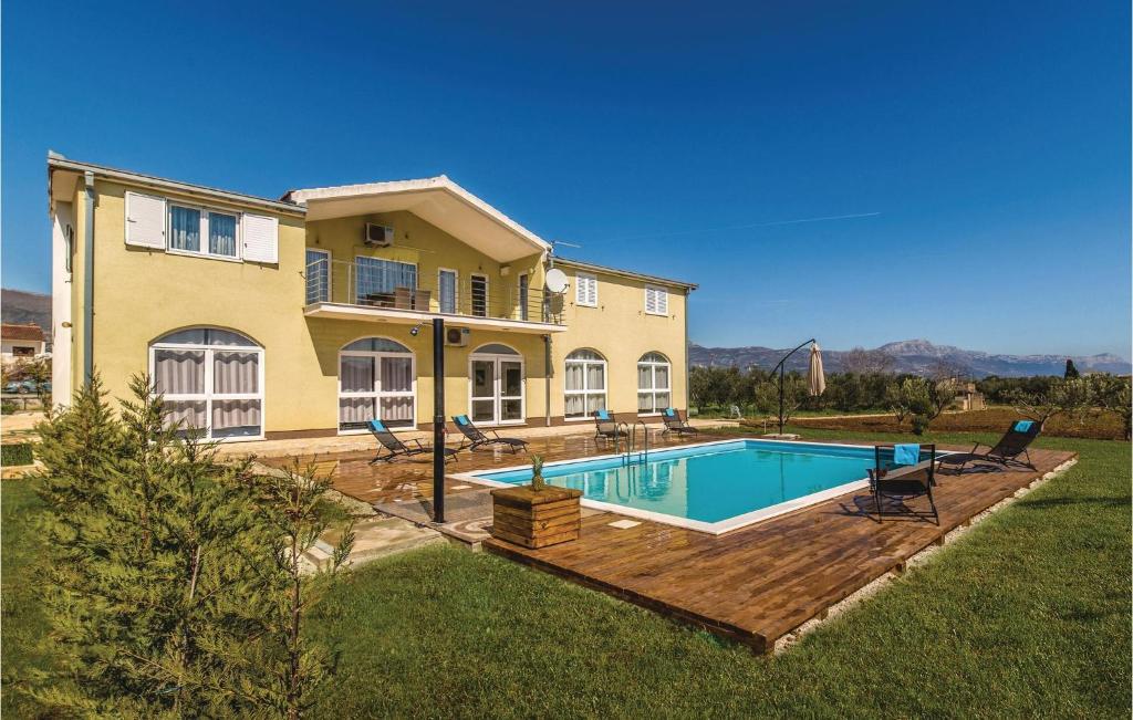 DjvuljeAmazing Apartment In Divulje With 2 Bedrooms, Wifi And Outdoor Swimming Pool的庭院中带游泳池的房子