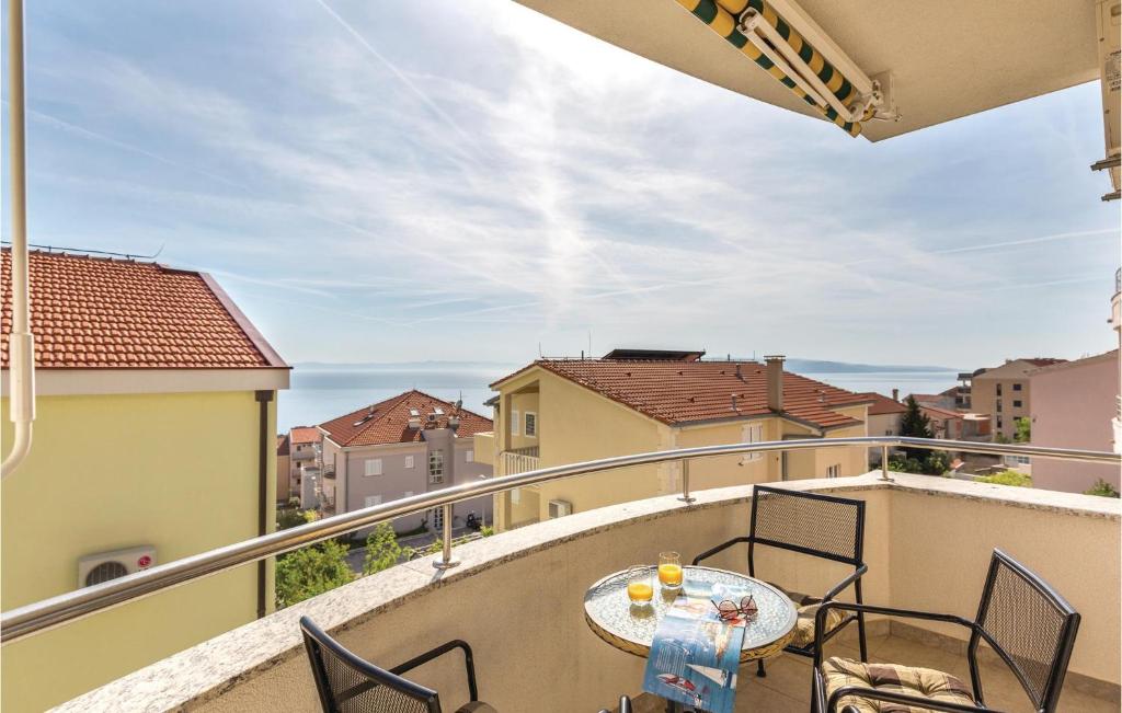 马卡尔斯卡Cozy Apartment In Makarska With Kitchen的阳台配有桌椅。