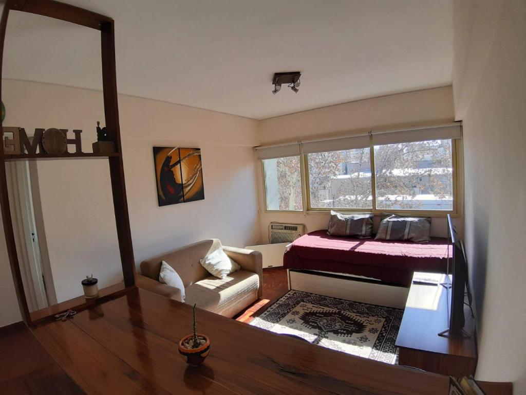 门多萨Alquiler Departamento Centro Mendoza Capital的一间卧室配有一张床和一个沙发