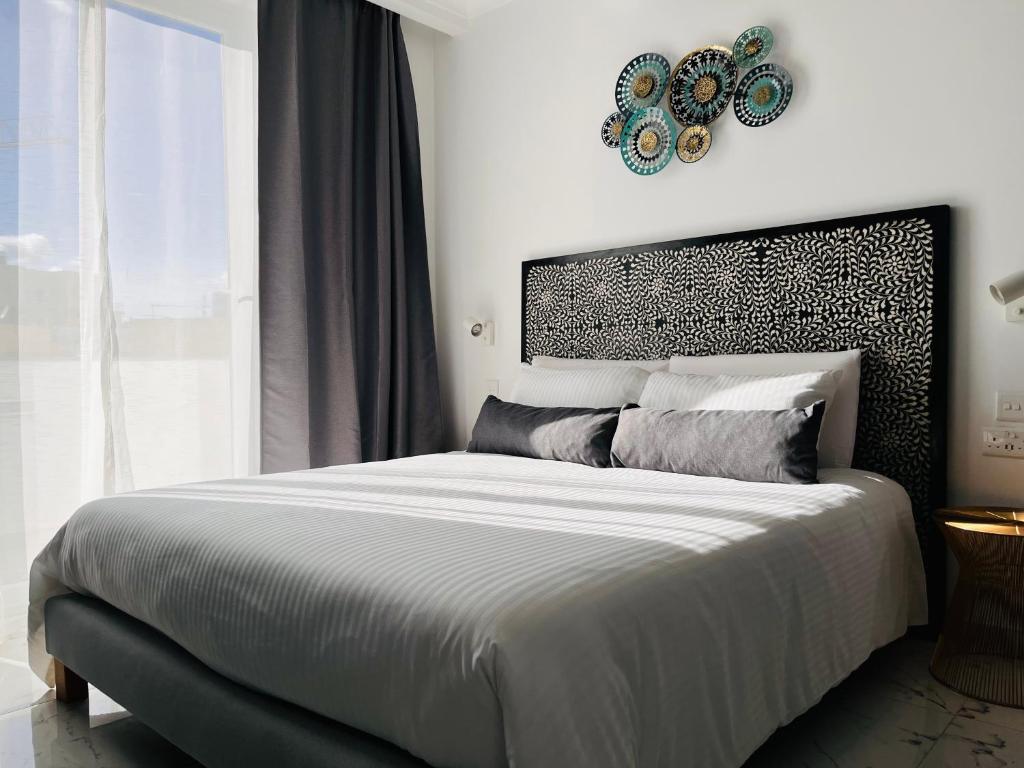 斯利马Apartments by Sliema promenade and beach的一间卧室设有一张大床和一个窗户。