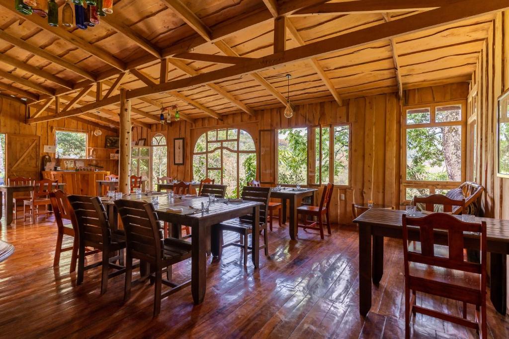 CopeyCedrela Eco-Lodge & Restaurante的一间铺有木地板并配有桌椅的用餐室