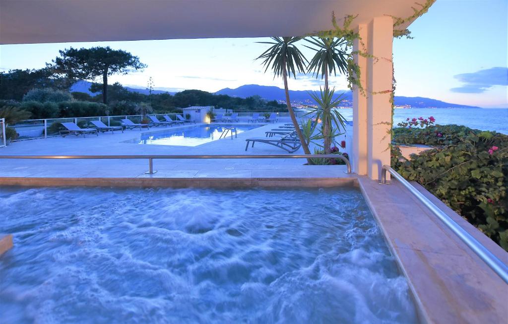 比居格利亚皮奈托酒店的一个带椅子和大海的大型小型游泳池