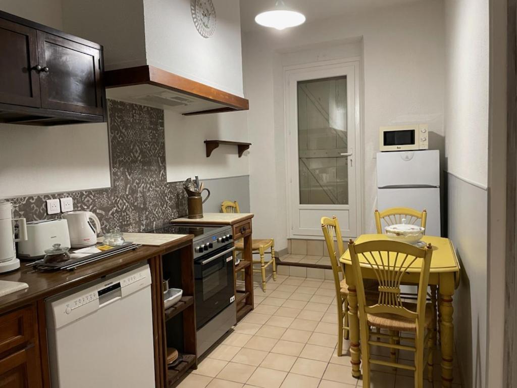 马赛le Cocooning Marseillais的厨房配有桌椅和台面