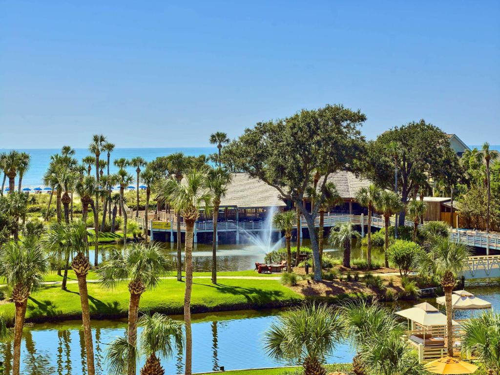 希尔顿黑德岛Sonesta Resort Hilton Head Island的享有度假村的空中景致,设有池塘和棕榈树