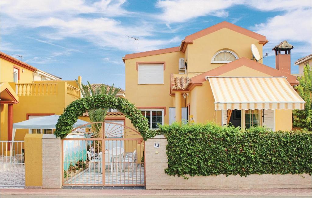 托雷维耶哈Amazing Home In Torrevieja With 3 Bedrooms, Wifi And Outdoor Swimming Pool的黄色的房屋,设有围栏和庭院