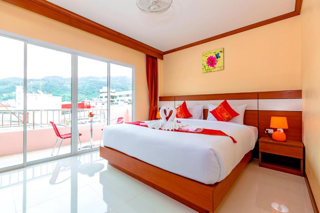 芭东海滩Phusita Hotel - SHA Certified的一间带大床的卧室和一个阳台
