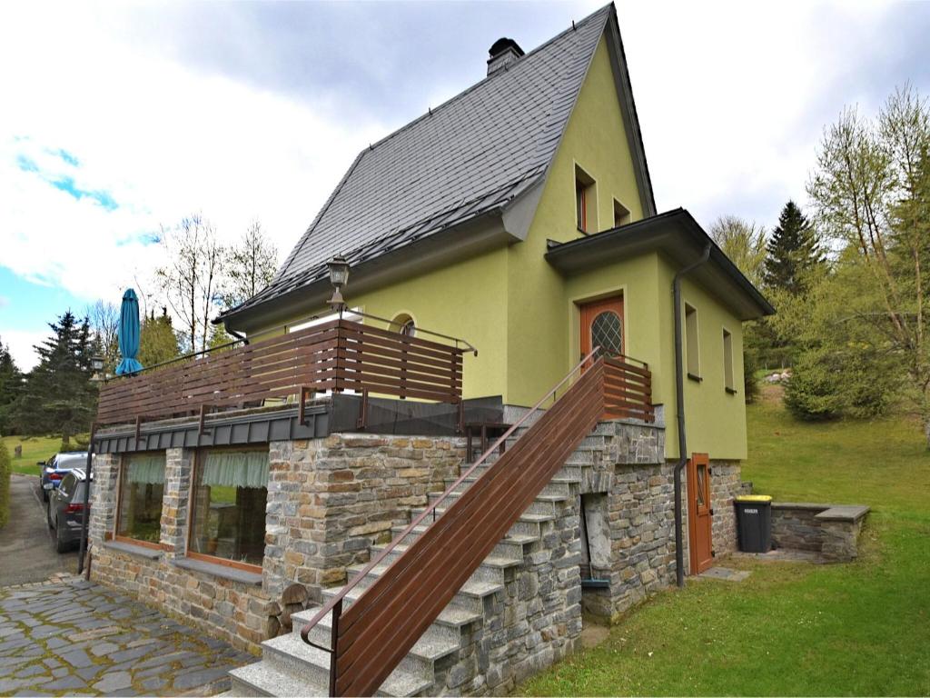 WeitersglashütteHoliday home with sauna in Wildenthal的一座黄色的小房子,上面有楼梯
