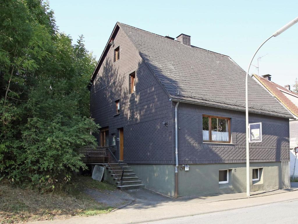 梅德巴赫Secluded Apartment in Medebach with Terrace的一座黑色屋顶的房子,上面有楼梯