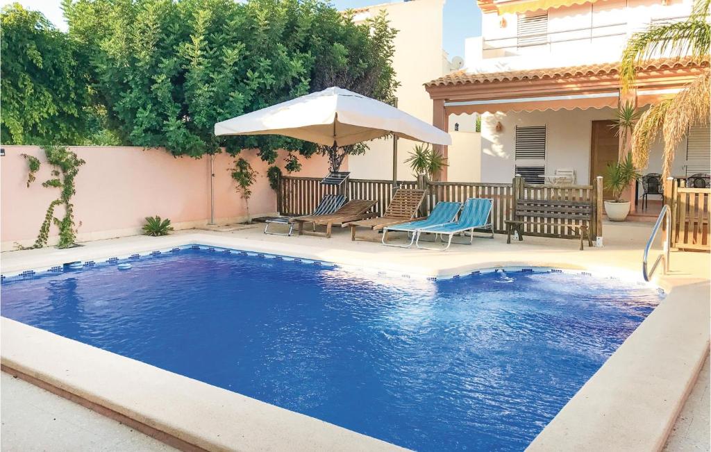 拉阿索亚Nice Home In La Azohia With Outdoor Swimming Pool的一个带遮阳伞和椅子的游泳池以及一座房子