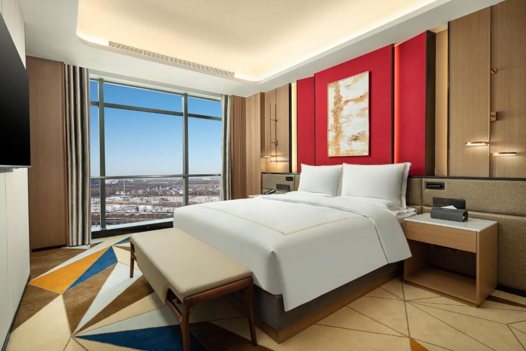 潍坊潍坊恒信拉昆塔温德姆酒店的卧室设有一张白色大床和大窗户