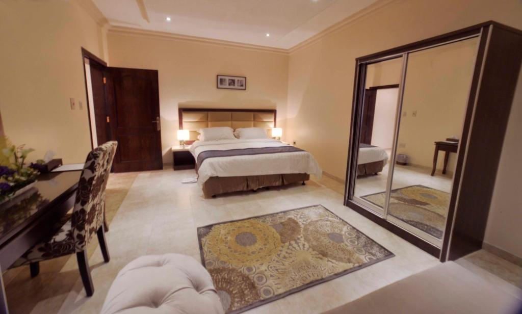 阿可贺巴城市套房公寓式酒店的一间卧室配有一张床和镜子