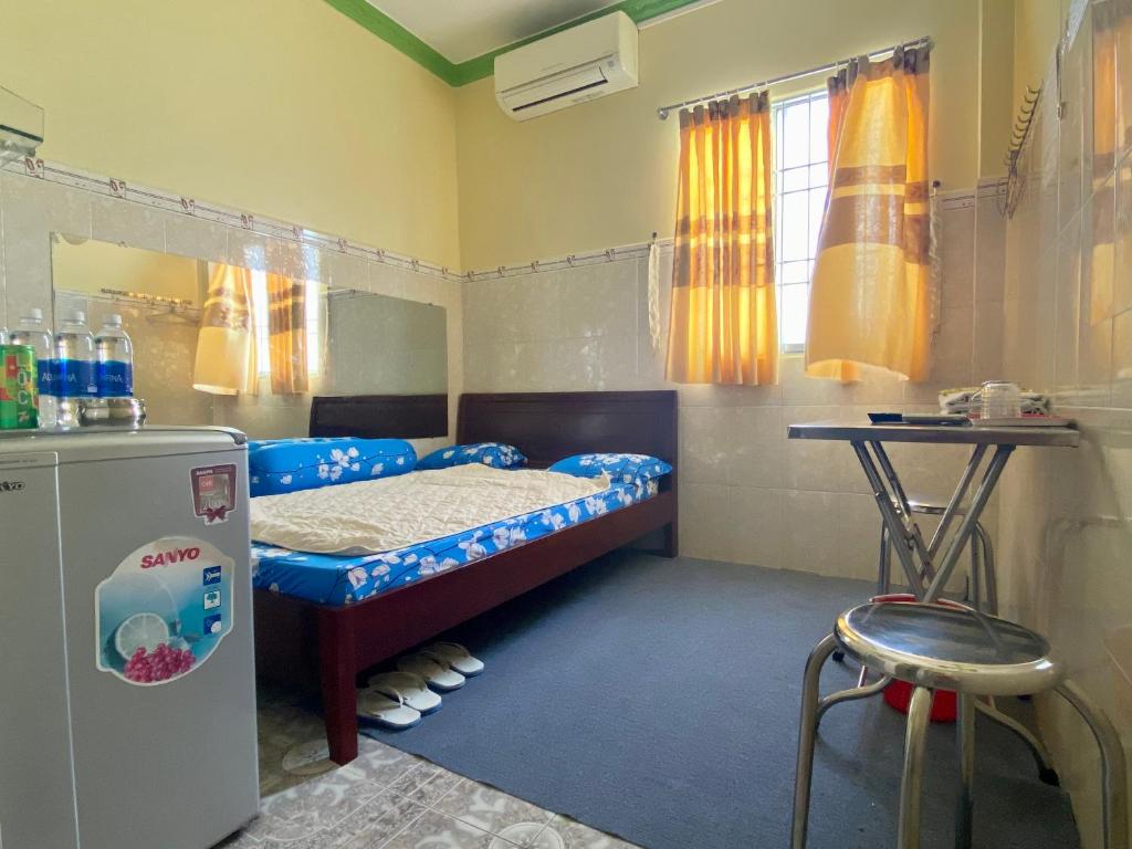 Bạc LiêuKhách Sạn Ngọc Cường的小房间设有一张床和一台冰箱