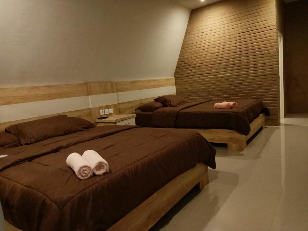 巴图Pagupon Camp Syariah的两张位于酒店客房的床,配有毛巾