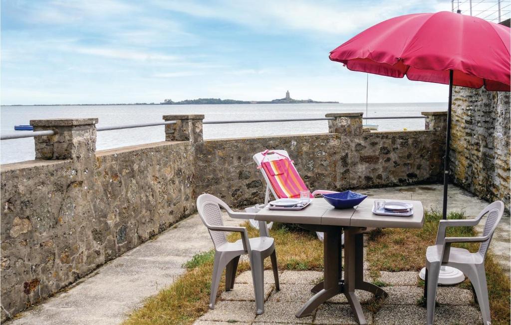 Morsalines乐里维格度假屋的一张桌子、两把椅子和一把红色雨伞