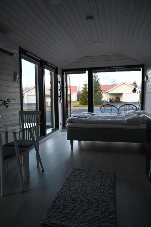 LumijokiWilla Rauha F的一间卧室配有一张床、一把椅子和窗户。