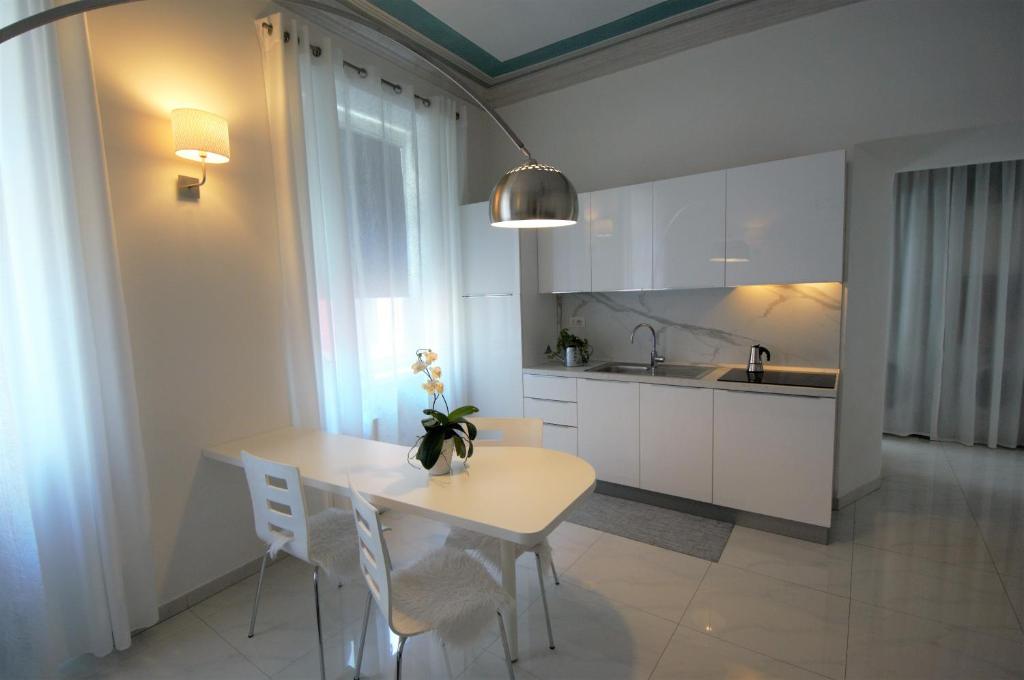 阿科Althamer Palace Apartments的厨房配有桌椅和水槽。