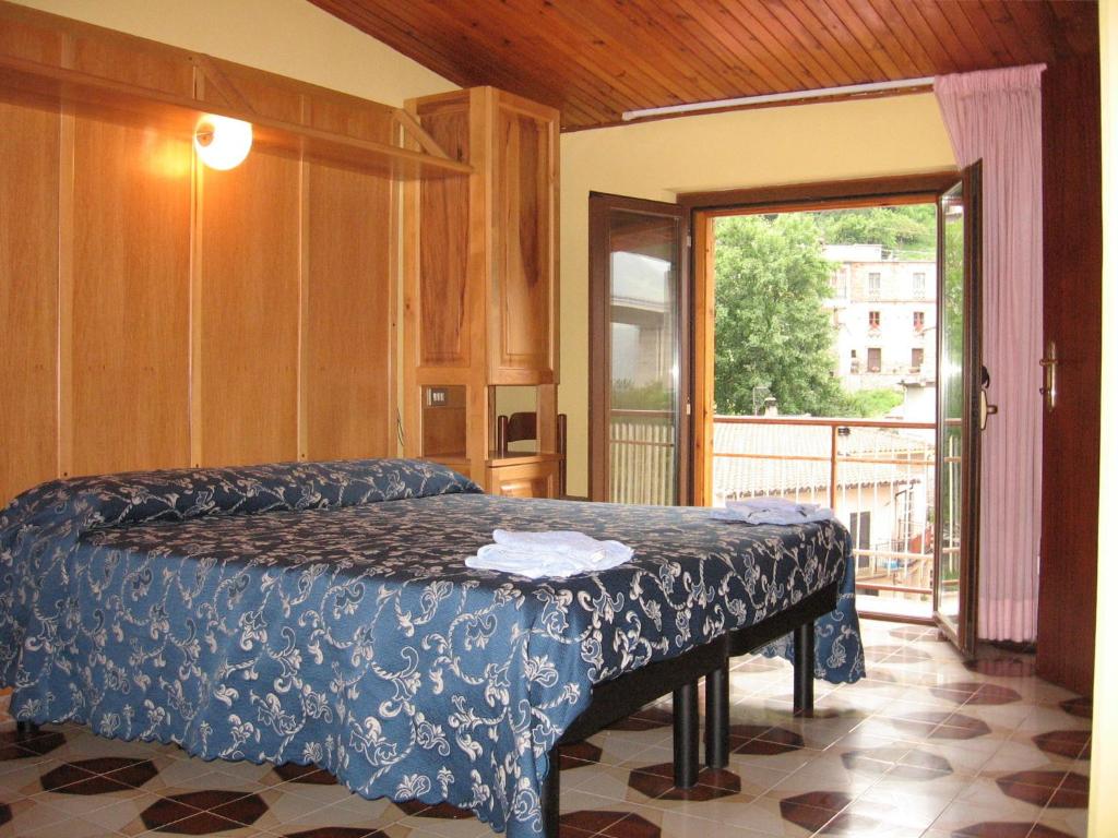 伊索拉德尔格兰萨索Hotel Casale的一间卧室设有一张床和一个滑动玻璃门