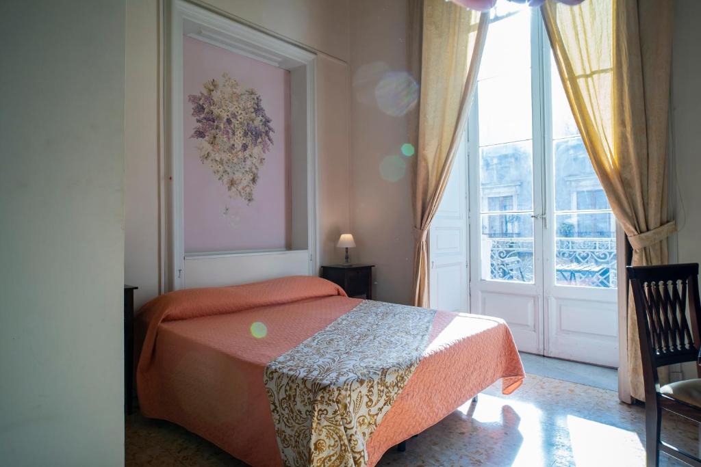 卡塔尼亚圣德梅特里奥酒店的一间卧室设有一张床和一个大窗户