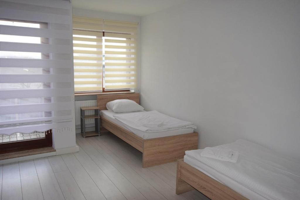 魏布林根AB Apartment Waiblingen的小房间设有两张床和窗户