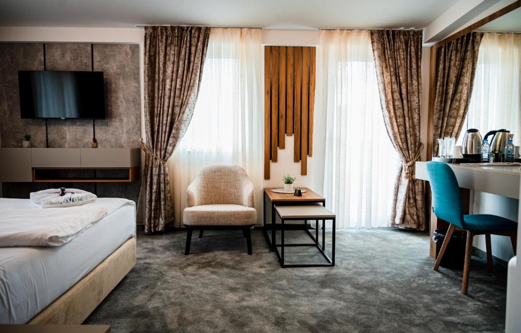 什蒂普Hotel Necko的配有一张床和一把椅子的酒店客房