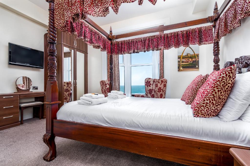 惠特比Riviera Guesthouse的一间卧室设有一张四柱床和窗户