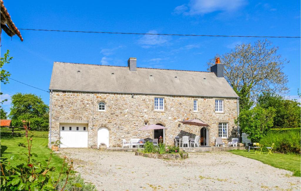 Saint-Martin-le-HébertAwesome Home In Bricquebec-en-cotentin的一座古老的石头房子,设有白色车库