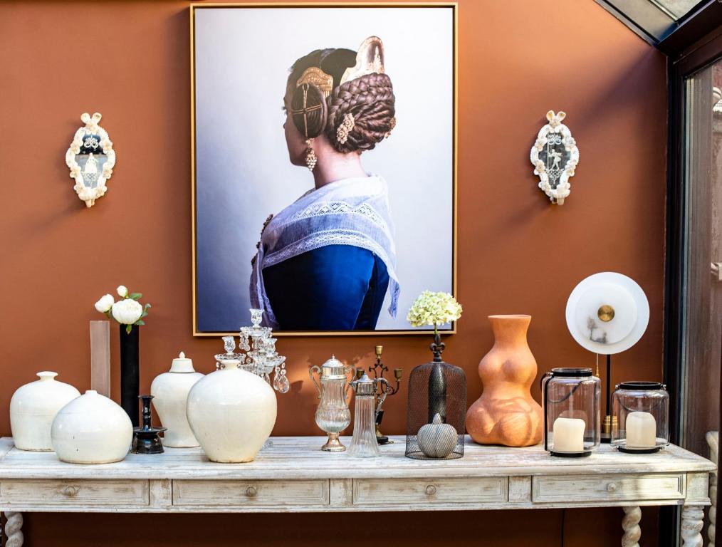 Sainte-RuffineLa Maison Ruffinoise的一张桌子,上面有花瓶和一张女人的照片