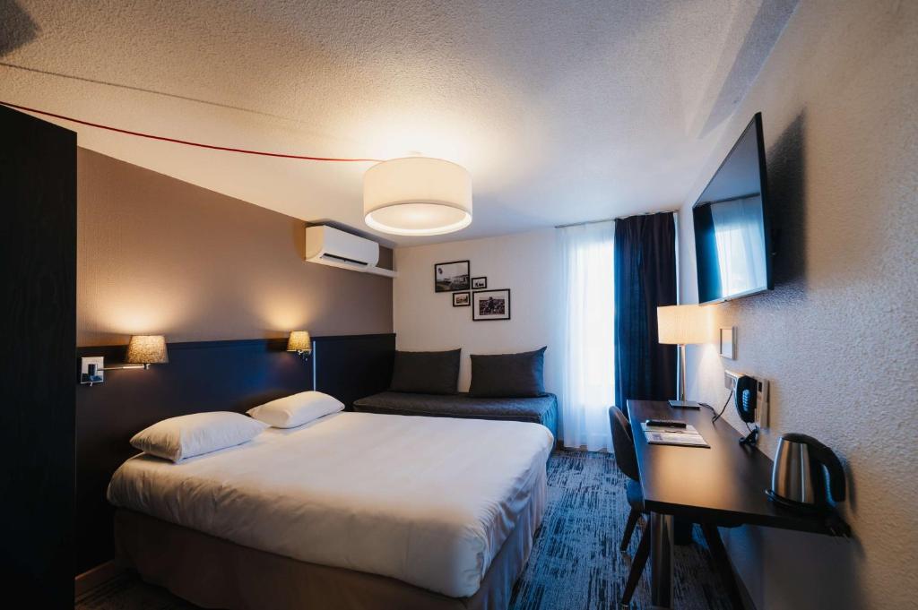 勒庞克涅特Sure Hotel by Best Western Châteauroux的酒店客房设有一张大床和一张书桌。