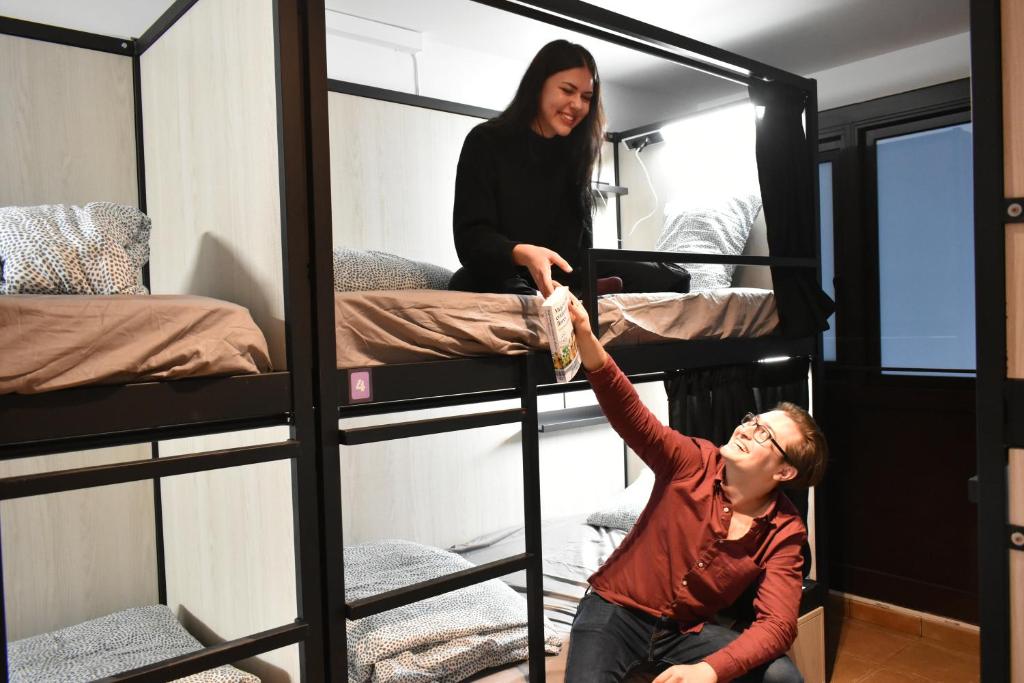 巴塞罗那Onefam Batlló的一位女士站在一个配有双层床的房间