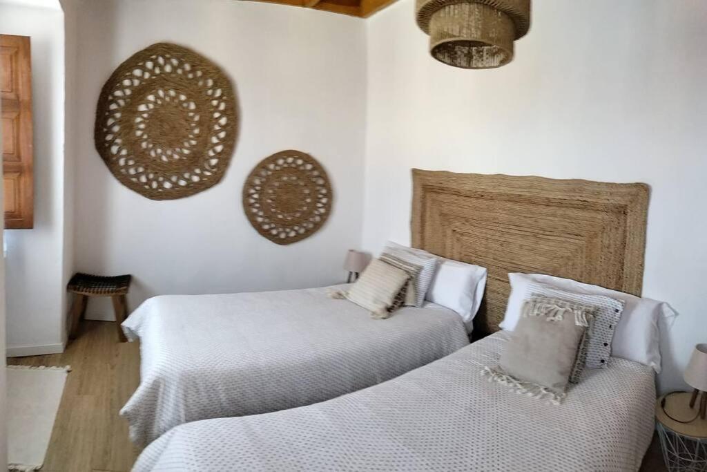 ArboleyaLa Casina Roja - Santolaya de Cabranes的白色墙壁客房的两张床