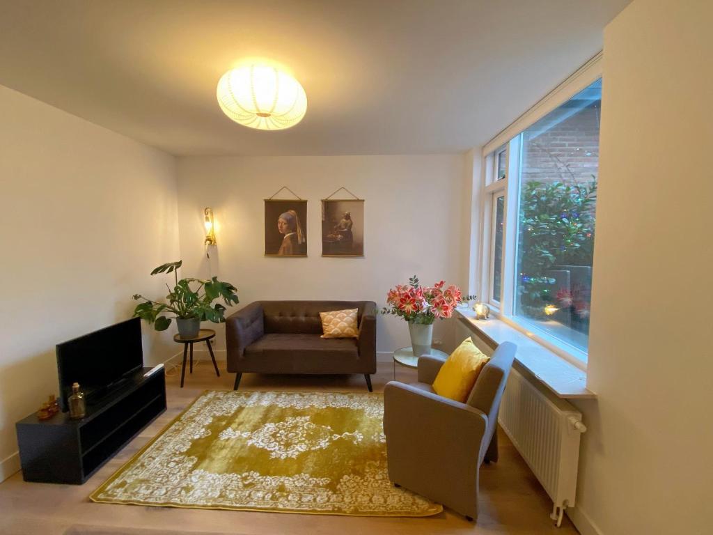 诺德韦克Fijn guesthouse的带沙发、椅子和窗户的客厅