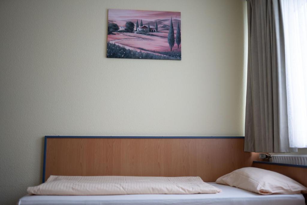 卡尔斯特RadlStadl - Brauhaus und Hotel的卧室内的一张床铺,墙上挂着一幅画