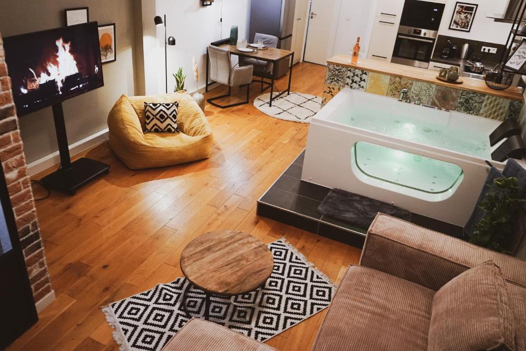 特里尔Stilvolles City-Loft mit privatem Whirlpool的一间客厅,位于房间中间,配有浴缸
