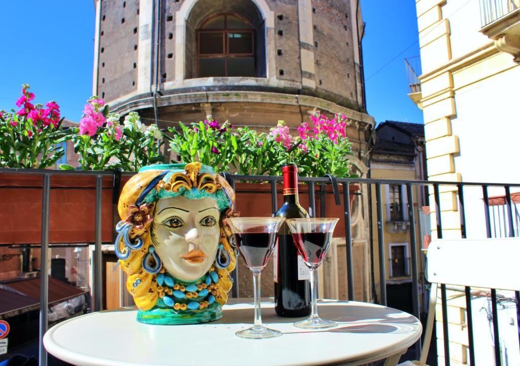 卡塔尼亚巴罗克住宿加早餐旅馆的一张带面罩的桌子和一杯葡萄酒