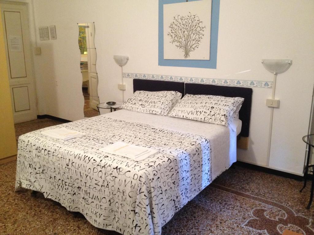 热那亚九百酒店的一间卧室配有一张带黑白色床罩的床。