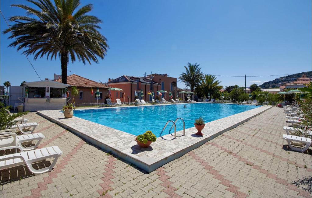 皮特拉利古Casa Borgo 1的一个带椅子和棕榈树的大型游泳池