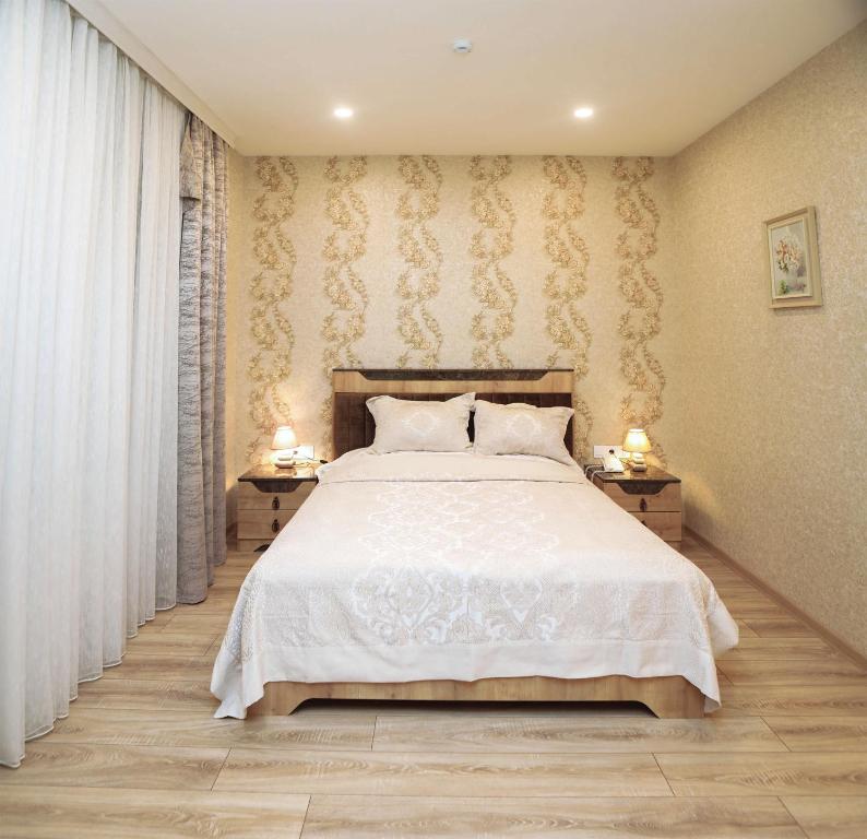 巴库MidCity Hotel的一间卧室配有白色床和2个床头柜