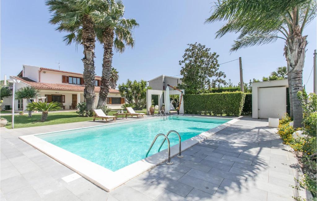 科米索Gorgeous Apartment In Comiso With Kitchen的一座棕榈树游泳池和一座房子