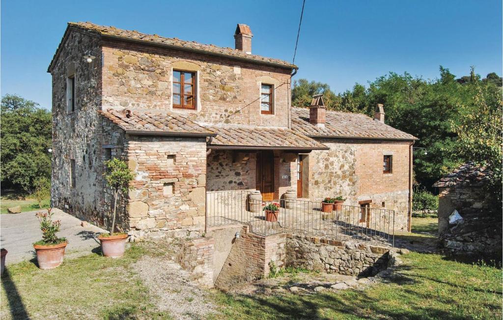 蒙特普齐亚诺Il Mulino Di Tresa的一座古老的石头房子,前面有盆栽植物