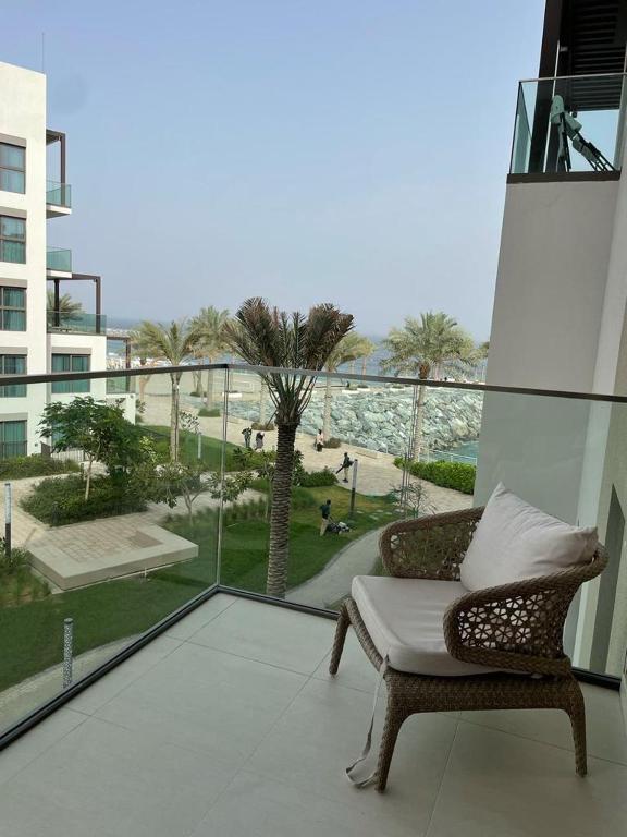 富查伊拉Address Beach Resort Fujairah - 2 bedroom apartment的一张柳条椅,坐在阳台上,眺望着大海