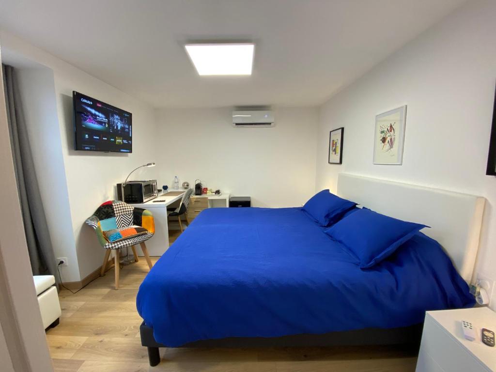 福梅尔Chambre d'hôtes indépendante de Pouzatel的一间卧室配有蓝色的床和一张书桌
