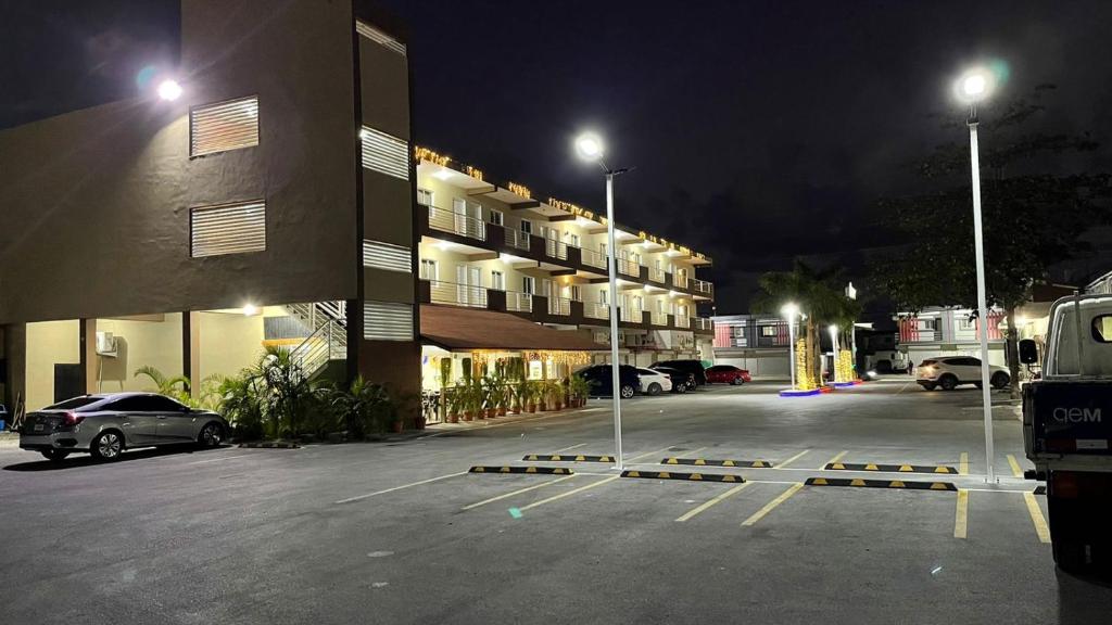 蓬塔卡纳My Home Hotel Punta Cana的夜间在大楼前的停车场