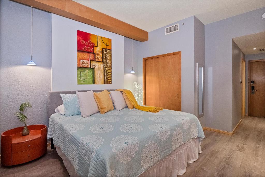 棕榈海岸Couples Getaway - Sweet Retreat - European Village Best Location的卧室配有一张床,墙上挂有绘画作品