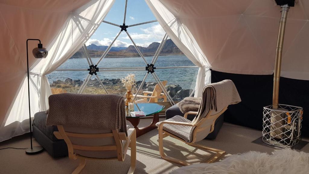 贝特斯托尔Jotunheimen Arctic Domes的一间带椅子和桌子的房间以及大窗户
