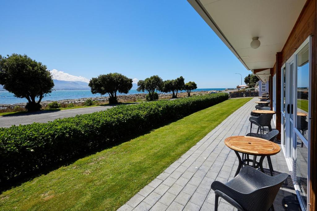 凯库拉全景汽车旅馆的一个带桌椅的庭院和大海